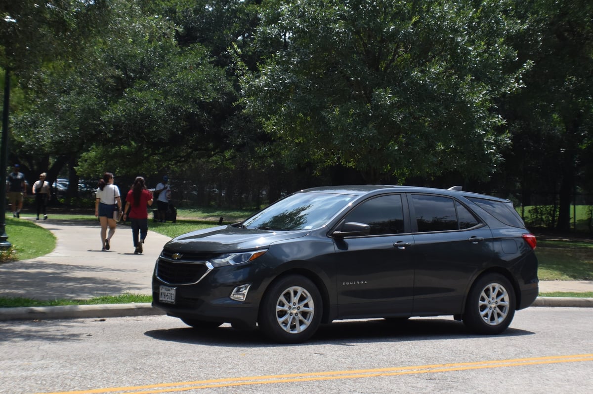 Houston, TX USA - Herman, Park June 6th, 2023 - Black Chevy Equinox SUV cruising near Hermann Park Conservatory